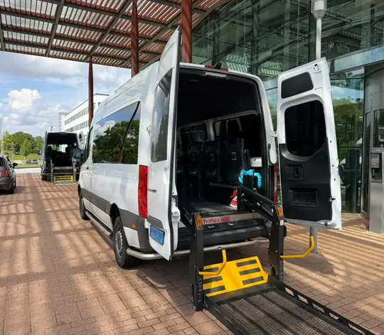 Professionele rolstoeltaxi chauffeur helpt klant in Den Haag